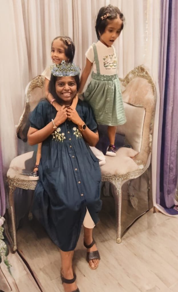 Sivamathi wearing a crown with two children